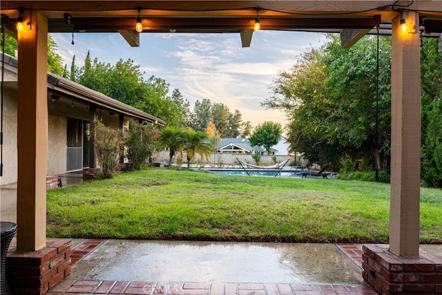 yard at dusk featuring a patio and a pool