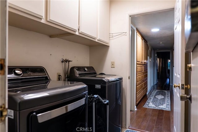 laundry area with washing machine and dryer, dark hardwood / wood-style flooring, and cabinets