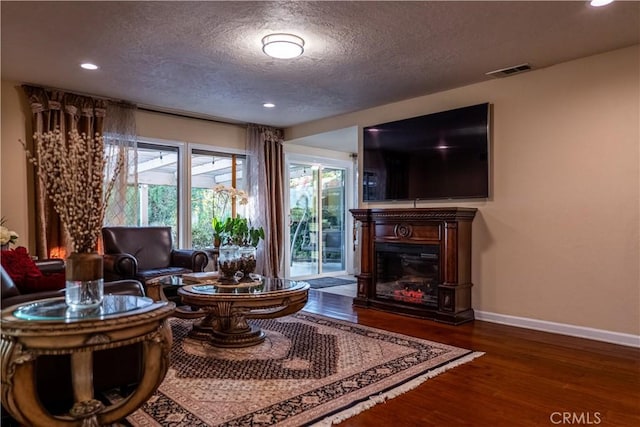 living area with dark hardwood / wood-style flooring and a textured ceiling