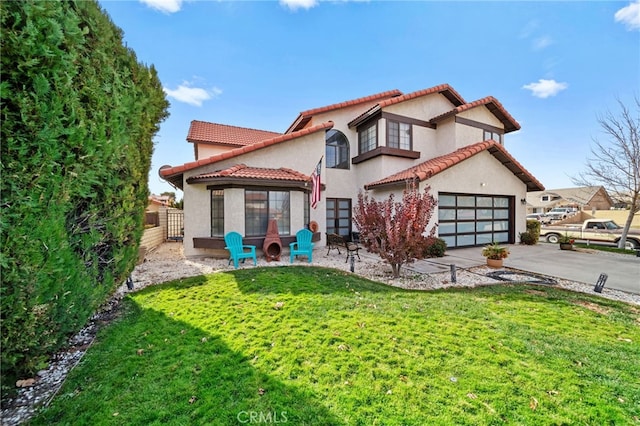 back of property featuring a lawn, a garage, and a patio