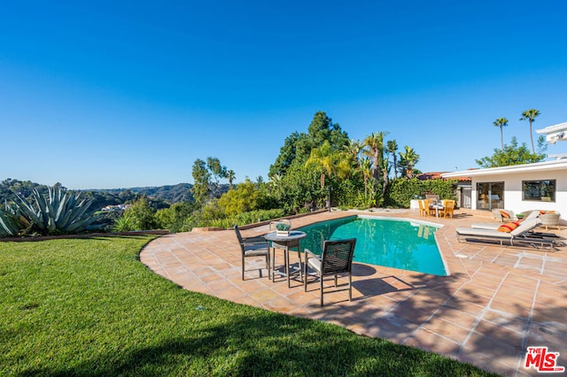 view of swimming pool featuring a yard and a patio