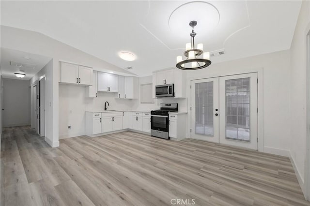 kitchen featuring white cabinetry, light hardwood / wood-style flooring, pendant lighting, and appliances with stainless steel finishes