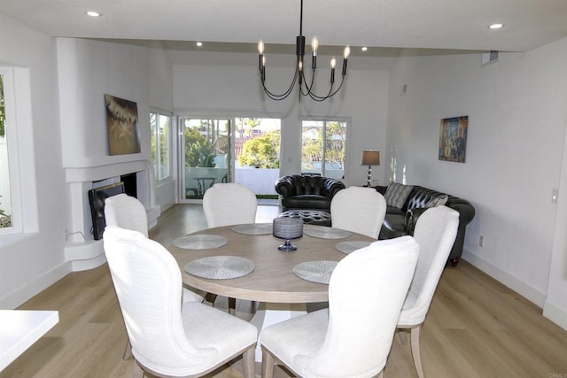 dining room with light hardwood / wood-style floors and a chandelier