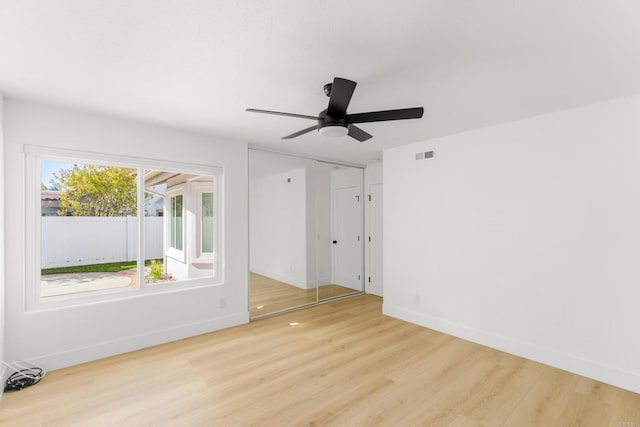 empty room with visible vents, ceiling fan, baseboards, and wood finished floors