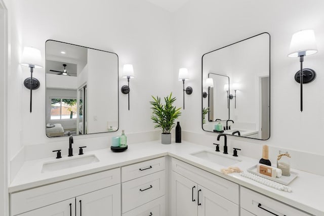 ensuite bathroom with double vanity, ensuite bath, a sink, and a ceiling fan