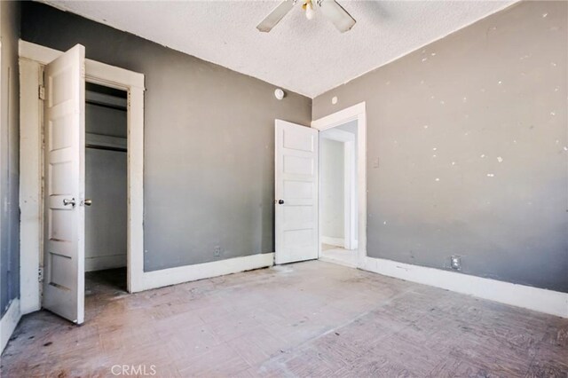 unfurnished bedroom featuring ceiling fan, a closet, and a textured ceiling