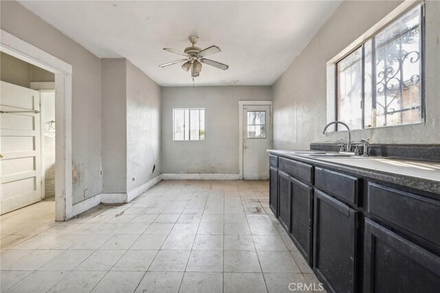 kitchen featuring light tile patterned floors, ceiling fan, and sink