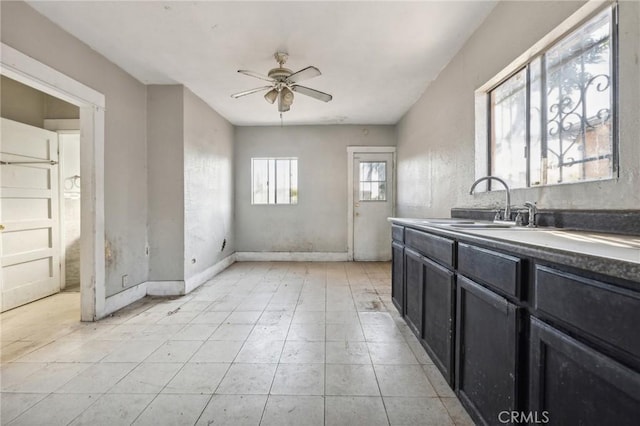 2853 E 6th St, Los Angeles, CA 90023 - kitchen with a sink, a ceiling fan, dark cabinets, and baseboards