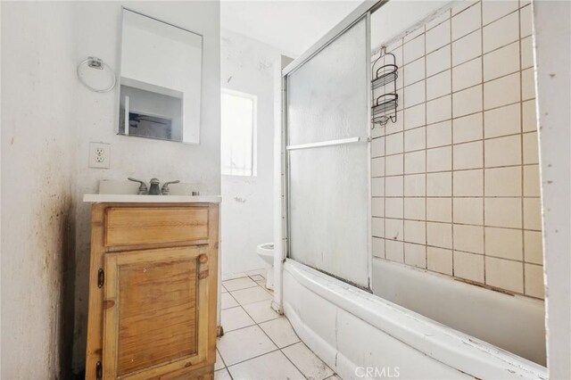 full bathroom featuring tile patterned floors, vanity, tiled shower / bath combo, and toilet