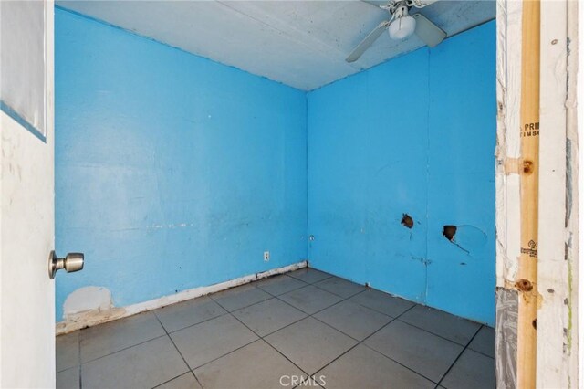 spare room with ceiling fan and light tile patterned floors