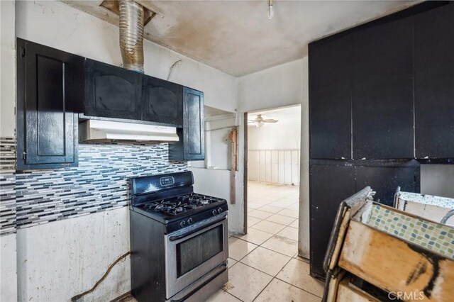 kitchen featuring tasteful backsplash, ceiling fan, light tile patterned floors, and stainless steel gas range
