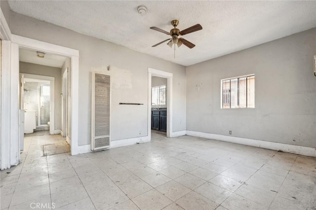 2853 E 6th St, Los Angeles, CA 90023 - empty room featuring a heating unit, a ceiling fan, baseboards, a textured ceiling, and a smoke detector
