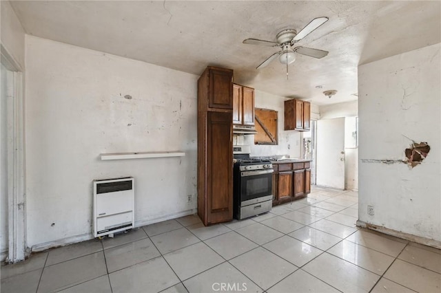 2853 E 6th St, Los Angeles, CA 90023 - kitchen featuring stainless steel gas range oven, heating unit, under cabinet range hood, and brown cabinets