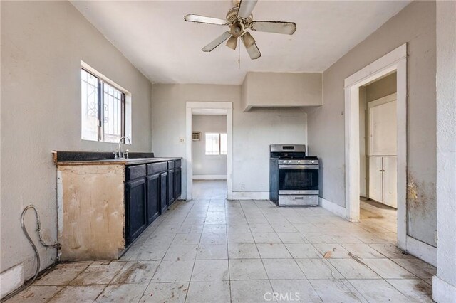 kitchen featuring stainless steel gas range oven, ceiling fan, plenty of natural light, and sink