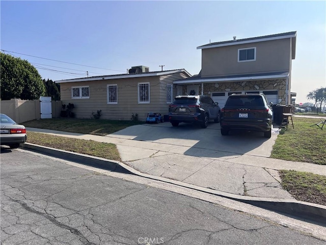 view of front facade with a garage and central AC