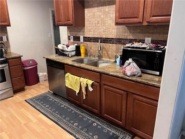 kitchen with sink, stainless steel appliances, light hardwood / wood-style flooring, backsplash, and stone countertops