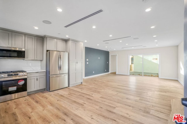 kitchen featuring gray cabinets, light wood-type flooring, and stainless steel appliances