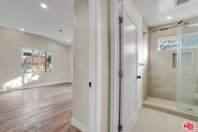 bathroom with hardwood / wood-style floors and lofted ceiling