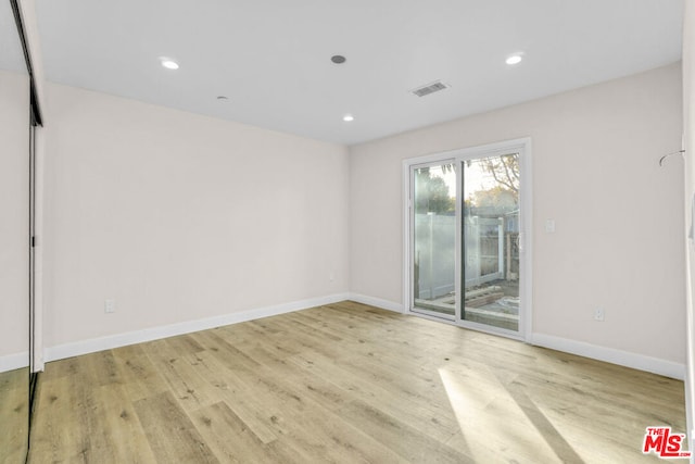 spare room with light hardwood / wood-style flooring