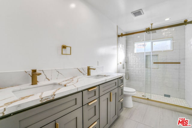 bathroom featuring vanity, toilet, and a shower with door