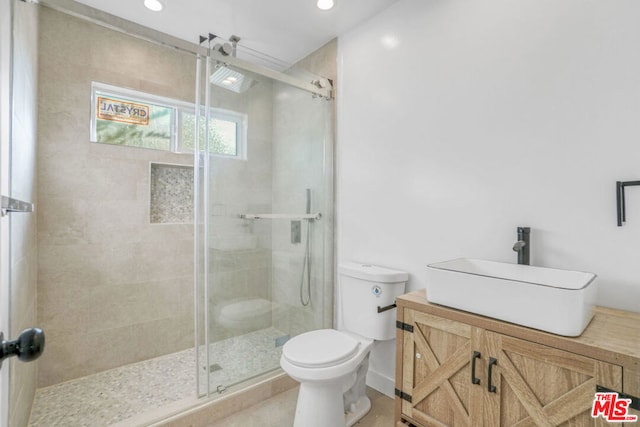 bathroom featuring an enclosed shower, vanity, and toilet