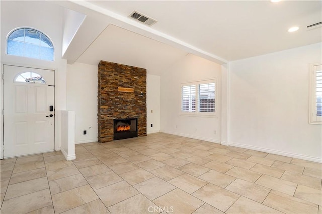 unfurnished living room featuring a large fireplace and lofted ceiling