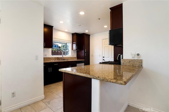 kitchen featuring white dishwasher, sink, light tile patterned flooring, light stone counters, and kitchen peninsula