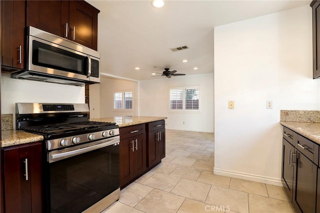 kitchen featuring ceiling fan, light tile patterned floors, light stone countertops, and appliances with stainless steel finishes