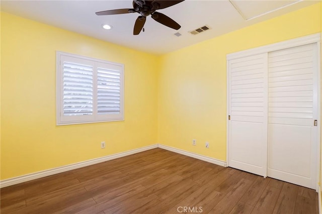 unfurnished bedroom featuring ceiling fan, a closet, and hardwood / wood-style flooring