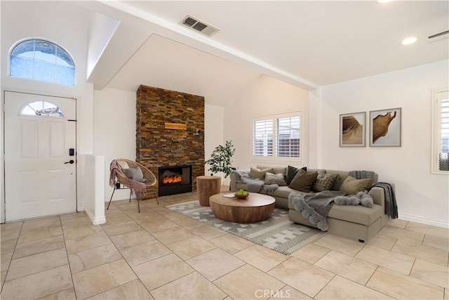 living room with a stone fireplace and lofted ceiling