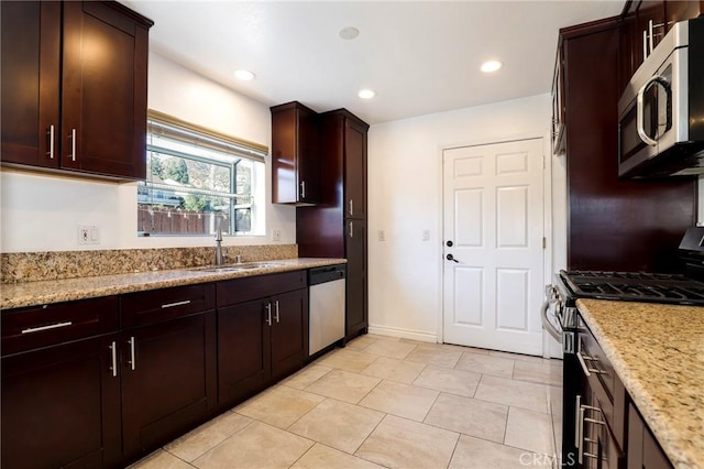 kitchen with sink, light stone countertops, and stainless steel appliances