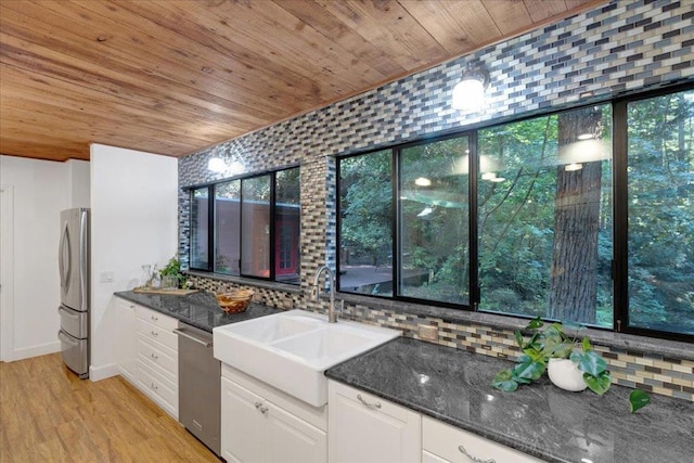 kitchen with dark stone countertops, white cabinetry, sink, and appliances with stainless steel finishes