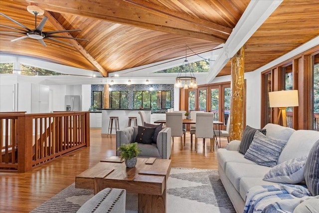 interior space featuring vaulted ceiling with beams, wood ceiling, ceiling fan with notable chandelier, and light hardwood / wood-style flooring