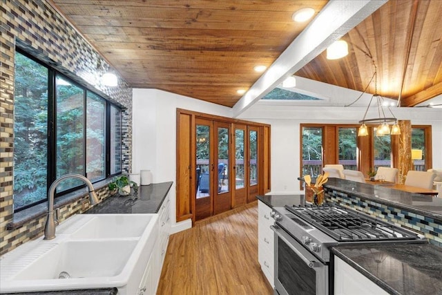 kitchen featuring a wealth of natural light, sink, and white cabinets