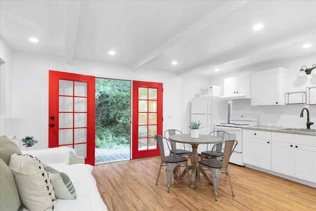 dining room with beamed ceiling, sink, and light hardwood / wood-style flooring