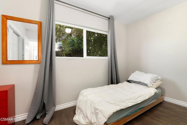 bedroom with dark hardwood / wood-style floors