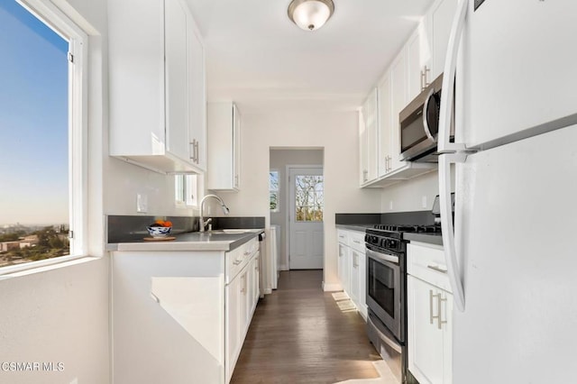 kitchen with white cabinets, dark wood-type flooring, sink, and stainless steel appliances