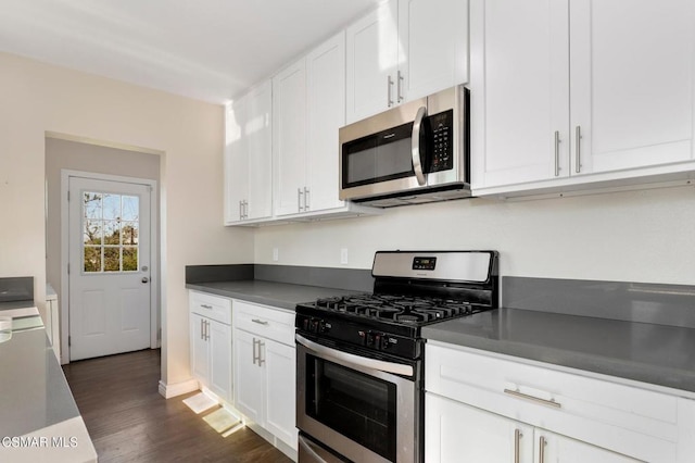 kitchen with dark hardwood / wood-style floors, appliances with stainless steel finishes, and white cabinets