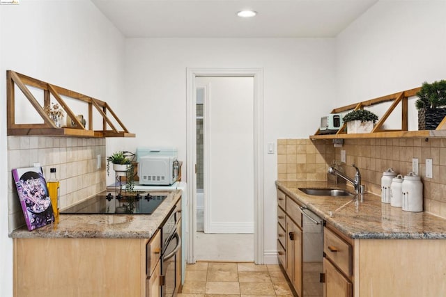 kitchen featuring light stone countertops, decorative backsplash, stainless steel appliances, and sink