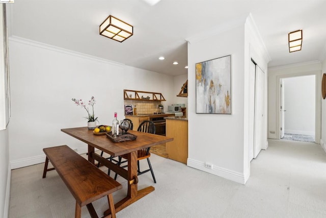 carpeted dining area with ornamental molding