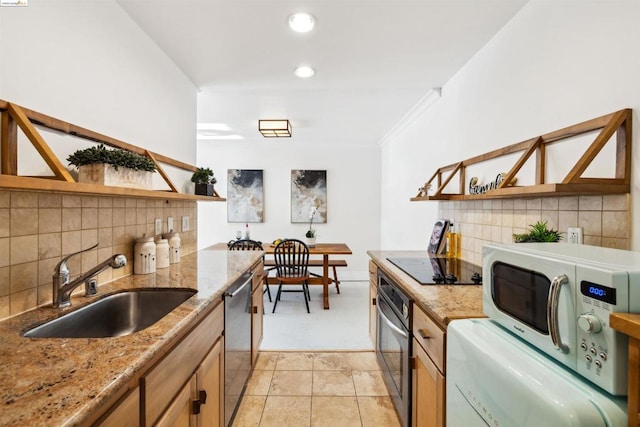 kitchen with appliances with stainless steel finishes, tasteful backsplash, light stone counters, and sink