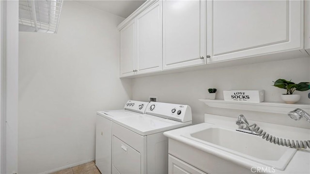 laundry room featuring cabinets, light tile patterned floors, washing machine and dryer, and sink