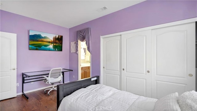 bedroom with dark hardwood / wood-style flooring and a closet