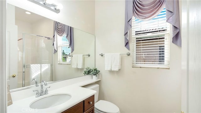 bathroom featuring vanity, a shower with curtain, toilet, and a wealth of natural light