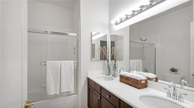 full bathroom with vanity, enclosed tub / shower combo, and toilet