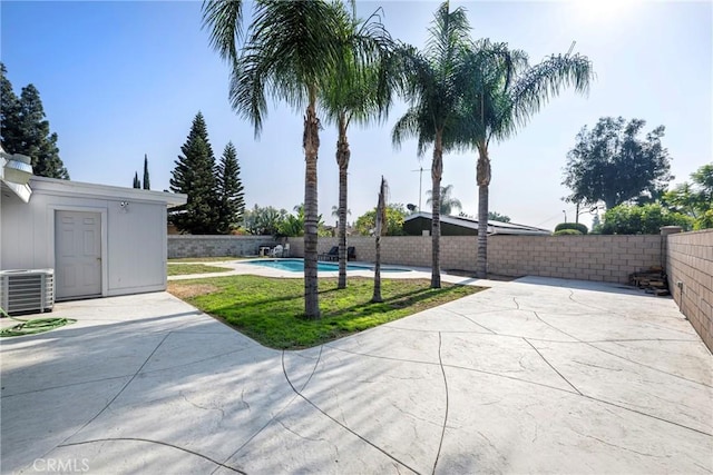 view of patio / terrace featuring a fenced in pool and central AC unit