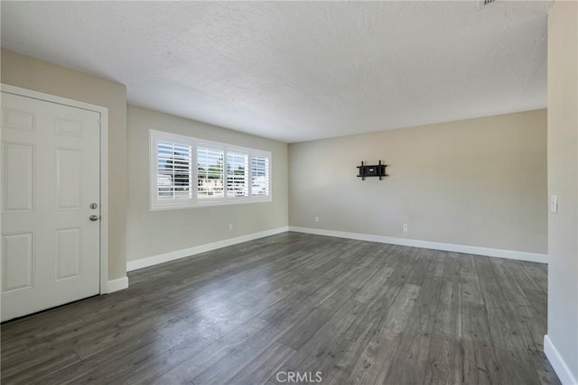 unfurnished room featuring a textured ceiling and dark hardwood / wood-style flooring