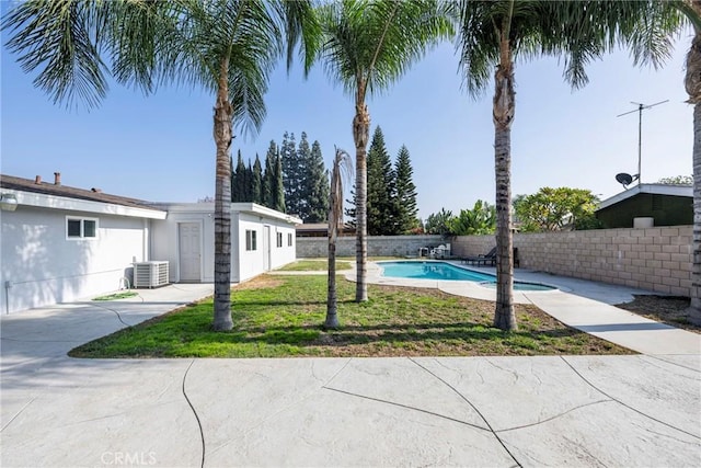 view of yard with a fenced in pool and cooling unit