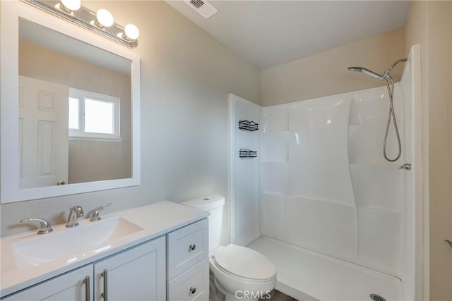 bathroom with a shower, vanity, and toilet