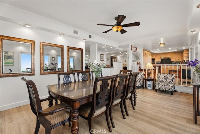 dining space with crown molding, ceiling fan, and light wood-type flooring